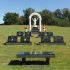 nelson family headstone monument with jesus statue and black granite bench