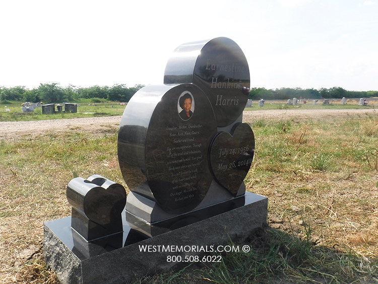 upright black gravestone with hearts